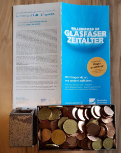 Bild mit symbolischem Geld im LKW und dem Flyer der Deutsche Glasfaser