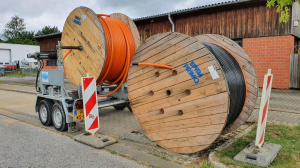 Glasfaserkabel aufgerollt hinter Baustellenbaken zur Sicherheit nach Feirabend des Bautrupp